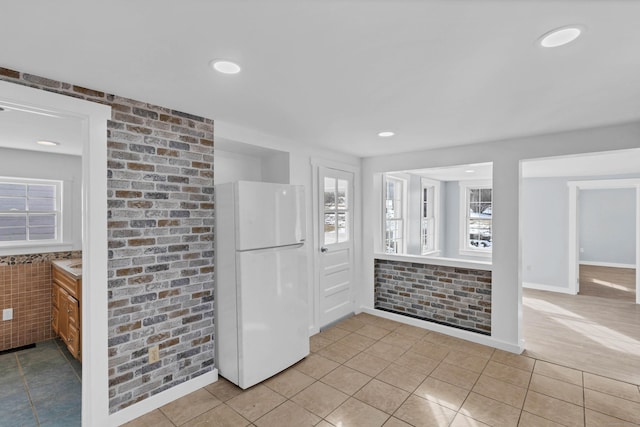 entryway featuring recessed lighting, brick wall, and light tile patterned floors