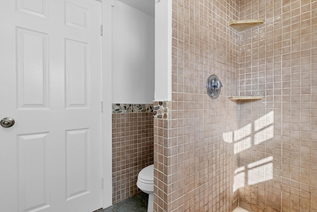 full bath featuring toilet, tile walls, and tiled shower