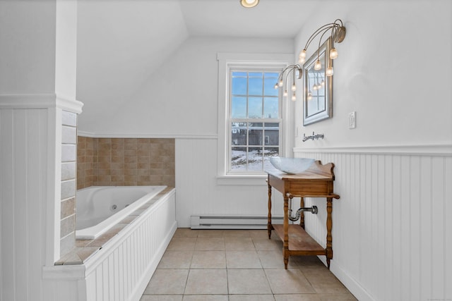 bathroom featuring a garden tub, tile patterned flooring, vaulted ceiling, and wainscoting