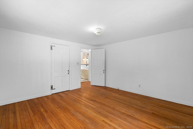 empty room with light wood-style flooring and baseboards