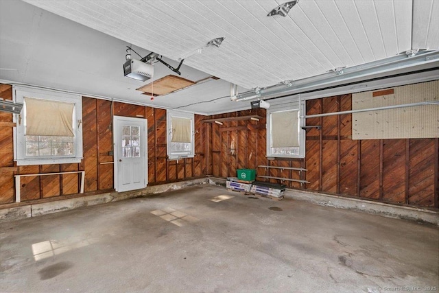 garage with wood walls and a garage door opener