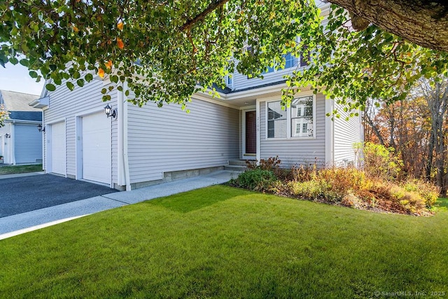 view of front of house with a garage, driveway, a front yard, and entry steps