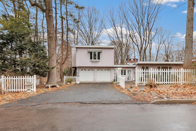 view of front of home featuring fence, driveway, and an attached garage