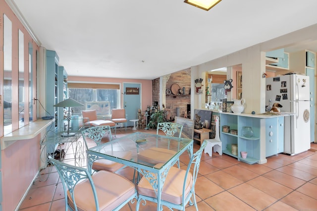 dining area with light tile patterned floors and a fireplace