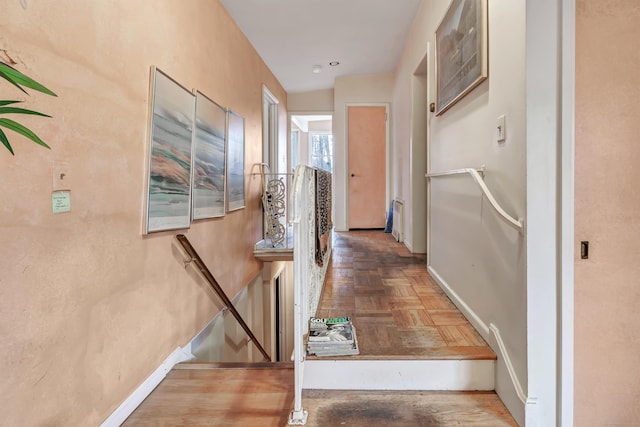 hall with baseboards and an upstairs landing