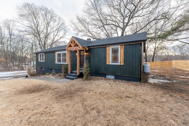 view of front of property featuring a shingled roof, crawl space, and fence