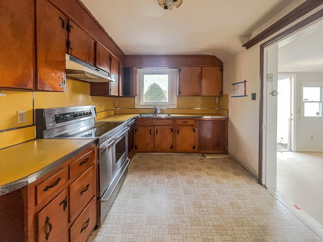 kitchen with under cabinet range hood, plenty of natural light, stainless steel electric stove, and a sink