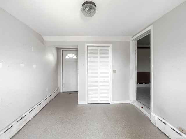 unfurnished bedroom featuring a baseboard heating unit, a closet, a baseboard radiator, and baseboards