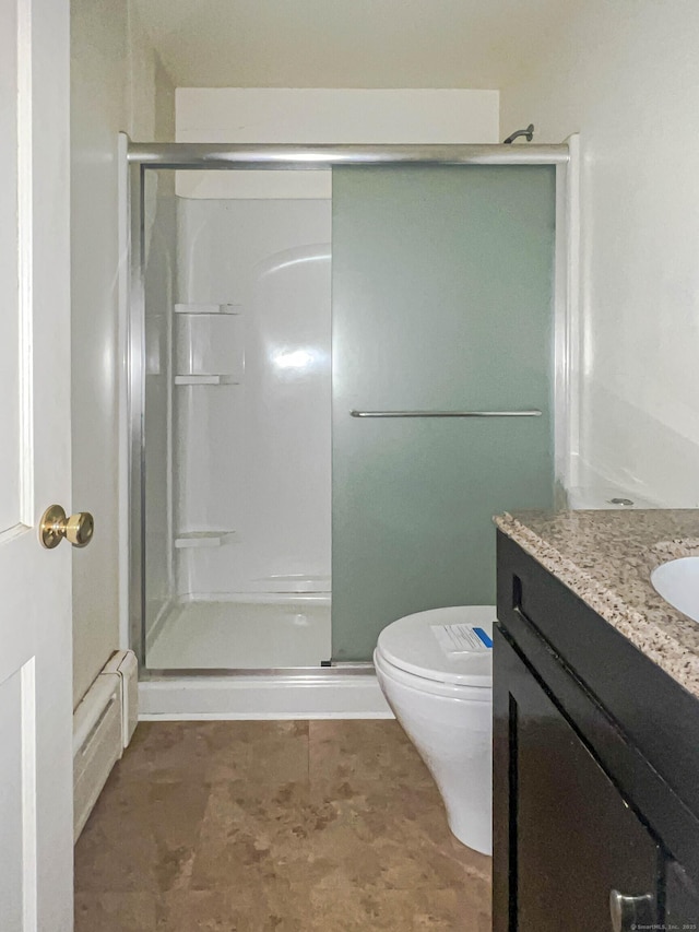 bathroom featuring a baseboard heating unit, vanity, a shower stall, and toilet