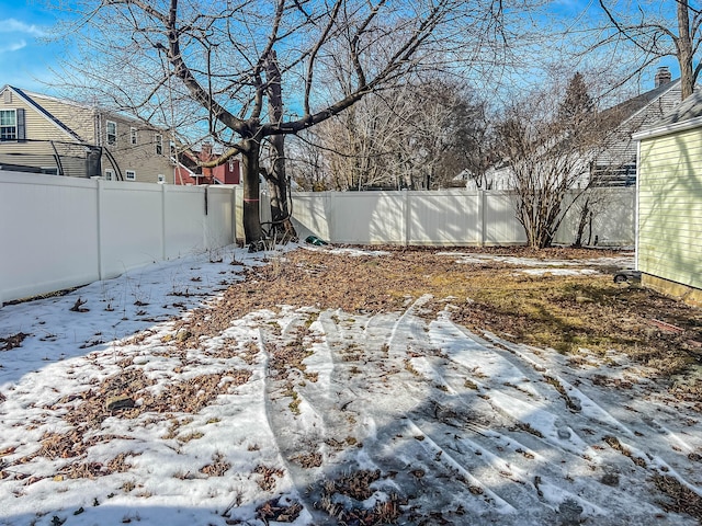 yard layered in snow with a fenced backyard