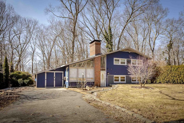 view of front of property featuring driveway and a chimney