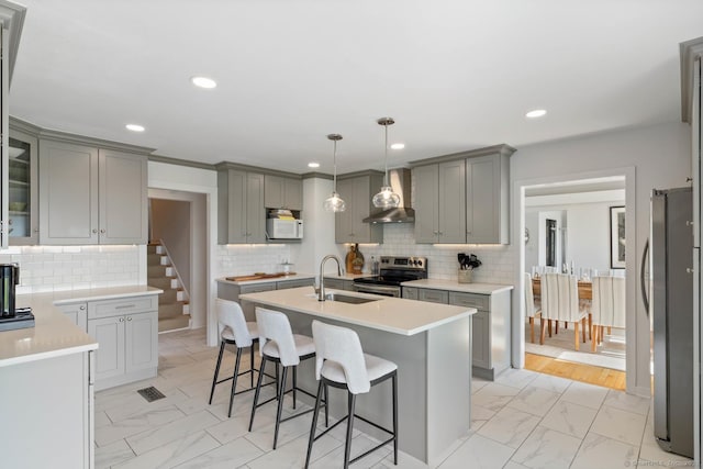 4 Old Fenwick Rd, Old Saybrook, CT 06475 - kitchen featuring appliances with stainless steel finishes, gray cabinets, light marble finish floors, wall chimney exhaust hood, and recessed lighting