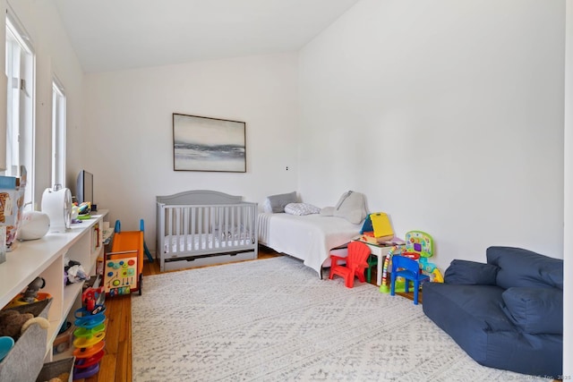 bedroom with vaulted ceiling and wood finished floors