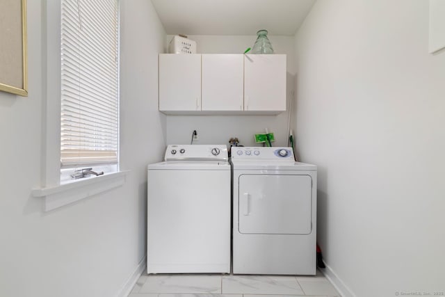 washroom with cabinet space, baseboards, washer and clothes dryer, and marble finish floor