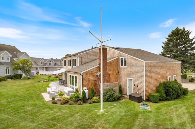 rear view of house featuring a residential view, roof with shingles, a yard, a patio area, and an outdoor living space