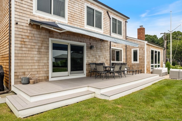 rear view of property with a deck, a yard, outdoor dining area, and an outdoor living space