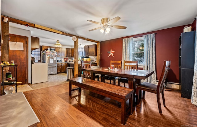 dining area with light wood finished floors, ceiling fan, and baseboard heating