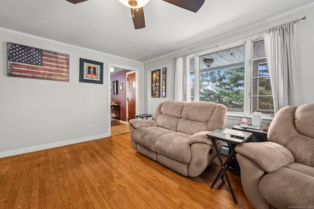 living room with ceiling fan, ornamental molding, light wood-style flooring, and baseboards