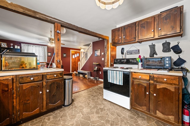 kitchen featuring white electric stove, light countertops, stone finish floor, and a toaster