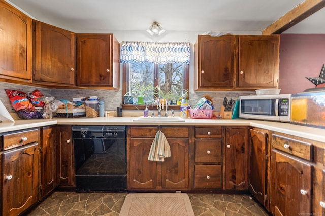 kitchen with black dishwasher, light countertops, stainless steel microwave, backsplash, and a sink