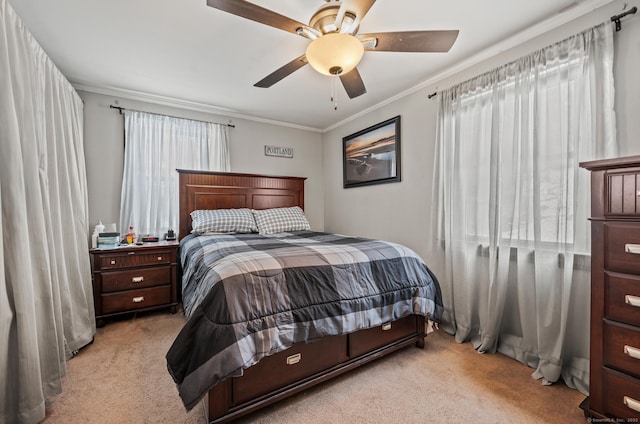 bedroom featuring ornamental molding, light colored carpet, and a ceiling fan