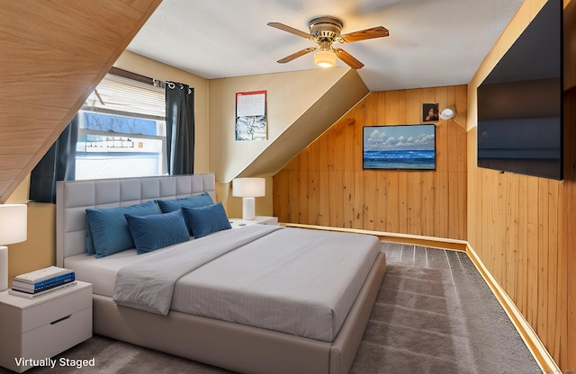 bedroom featuring a ceiling fan, carpet flooring, and wood walls