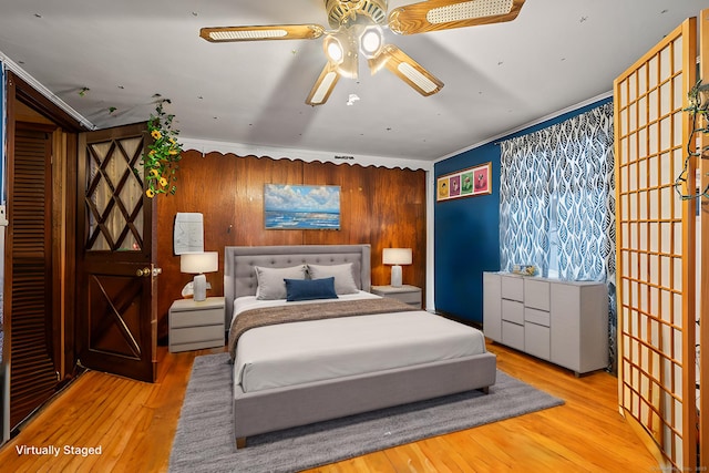 bedroom with ornamental molding and wood finished floors