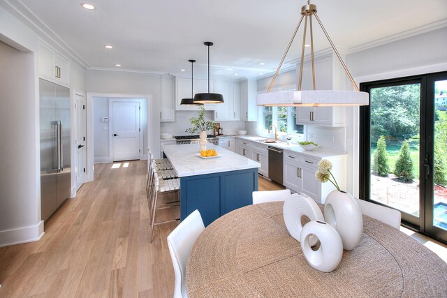 kitchen featuring ornamental molding, stainless steel appliances, backsplash, and a center island