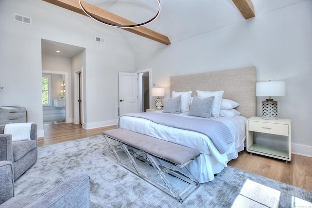 bedroom featuring visible vents, beamed ceiling, and wood finished floors