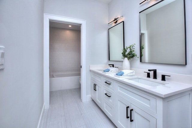 bathroom with a tub to relax in, double vanity, toilet, a sink, and baseboards