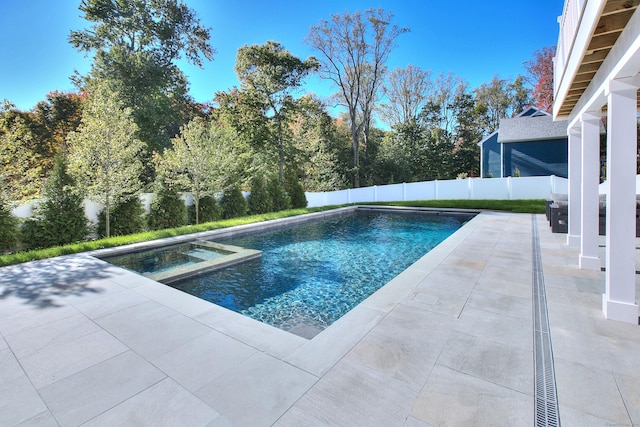 view of pool with a patio area, a fenced backyard, and a pool with connected hot tub