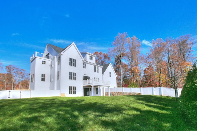 back of house with a balcony, a yard, a fenced backyard, and a gate