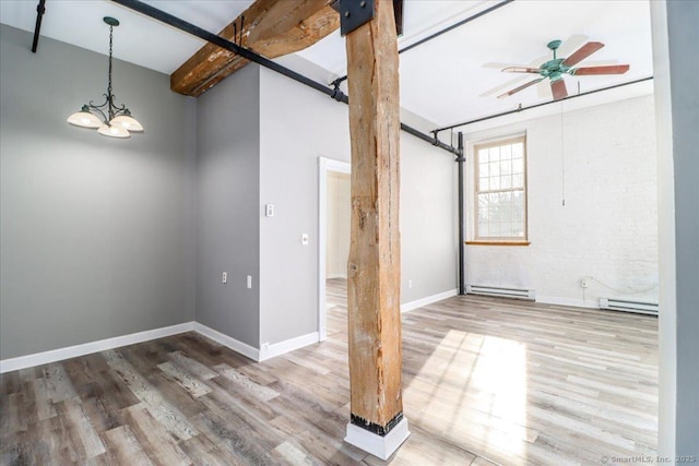 unfurnished room featuring baseboard heating, beamed ceiling, and wood finished floors