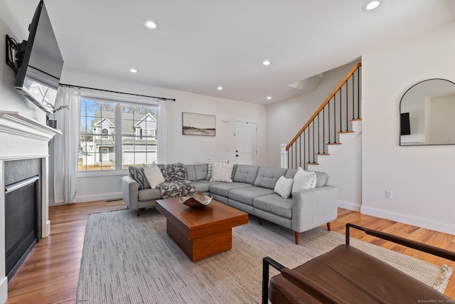 living room featuring baseboards, light wood-type flooring, and recessed lighting