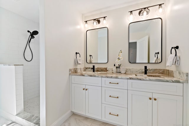 bathroom with a sink, marble finish floor, double vanity, and walk in shower