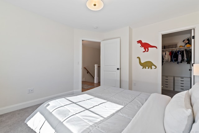 carpeted bedroom featuring a closet, a spacious closet, and baseboards