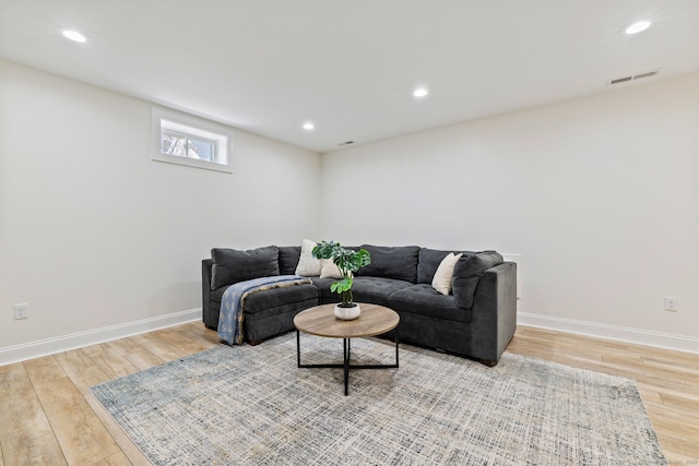 living room with light wood-style floors, baseboards, visible vents, and recessed lighting