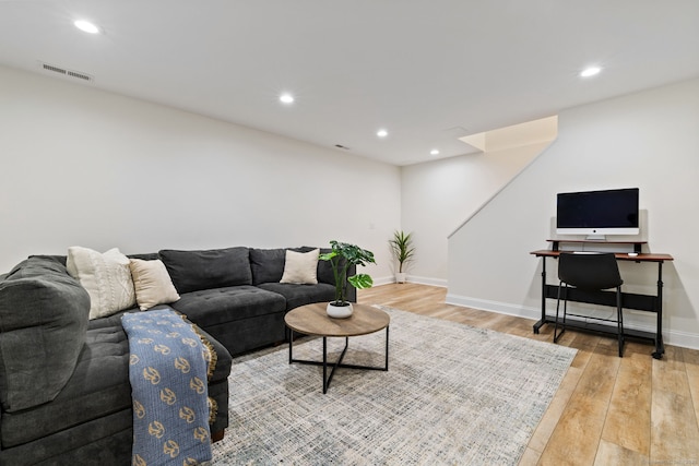 living room with light wood-type flooring, visible vents, baseboards, and recessed lighting