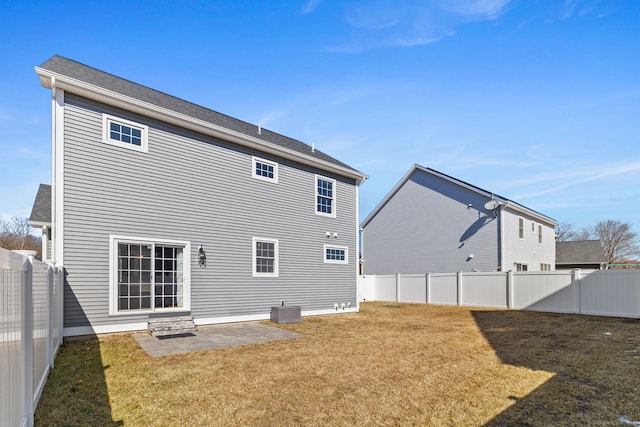 back of house with a fenced backyard, a yard, central AC unit, and a patio