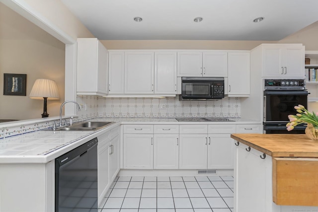 kitchen featuring a sink, black appliances, white cabinetry, and visible vents