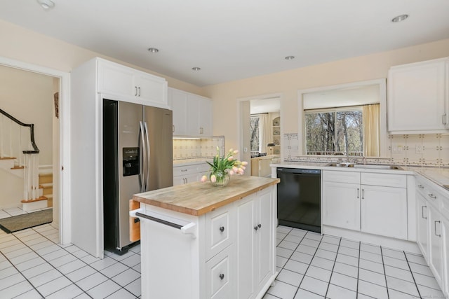 kitchen with stainless steel fridge with ice dispenser, dishwasher, backsplash, a kitchen island, and butcher block counters