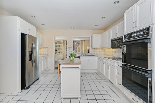 kitchen featuring white cabinets, backsplash, and black appliances