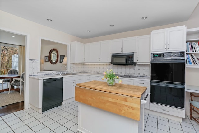 kitchen featuring a sink, white cabinets, black appliances, and tasteful backsplash