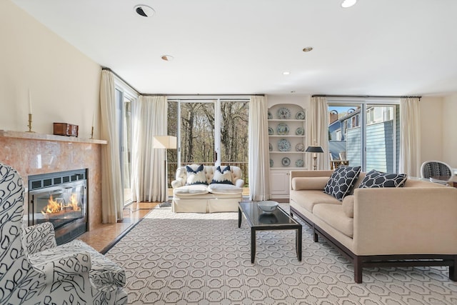 living area with recessed lighting and a glass covered fireplace