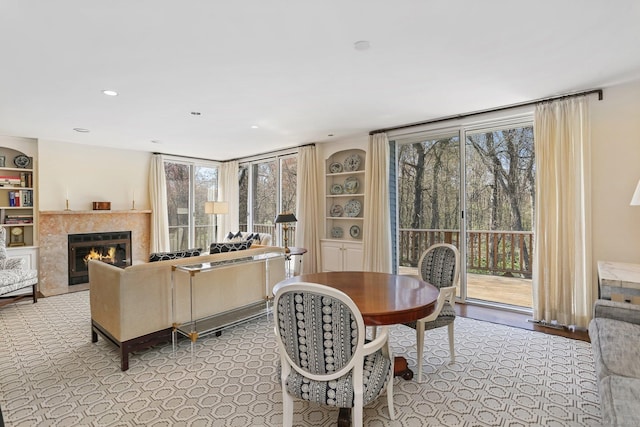 dining space with a tiled fireplace and built in features