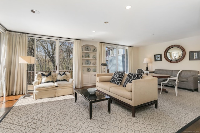 living area featuring recessed lighting, built in shelves, and a healthy amount of sunlight