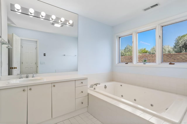 bathroom featuring a jetted tub, vanity, tile patterned floors, and visible vents