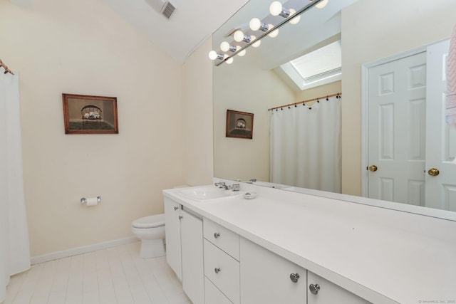 bathroom featuring vaulted ceiling with skylight, vanity, toilet, baseboards, and visible vents