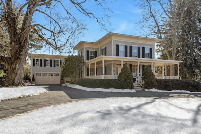 view of front of property featuring a garage, covered porch, and aphalt driveway