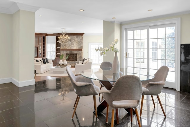 dining area with a stone fireplace, a wealth of natural light, and crown molding